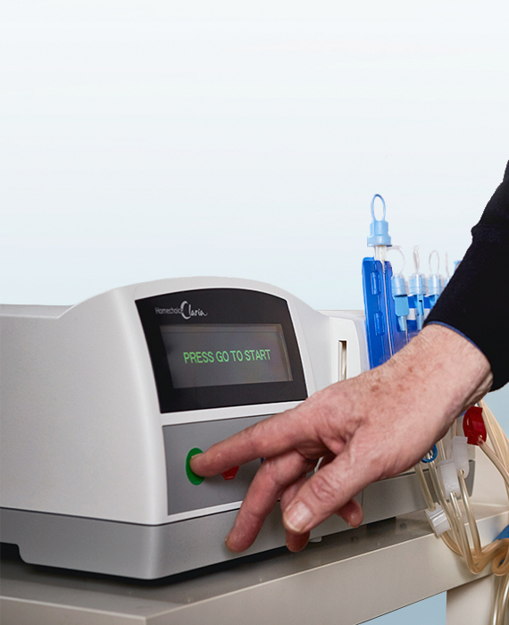 Close up of a patient pressing a start button on the Homechoice Claria system
