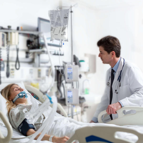 Doctor sitting with patient in hospital bed